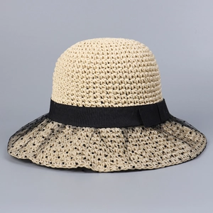 Detail of beige straw hat featuring black mesh polka dot veil and elegant bow ribbon