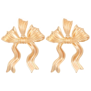 Detailweergave van elegante gouden strik oorknopjes met een getextureerde metaalafwerking
