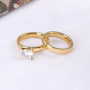 Detail eines vergoldeten Partnerring-Sets mit Zirkonia auf weißem Kunstfell-Hintergrund