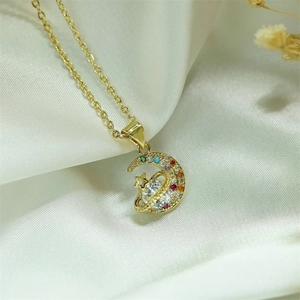Macro view of gold crescent moon and planet pendant with colorful zircon stones