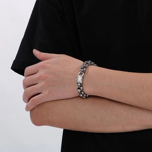 Gothic punk style stainless steel skull bracelet worn on wrist with vintage silver finish