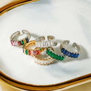 Luxurious open rings with colorful baguette cut crystals on a decorative white plate