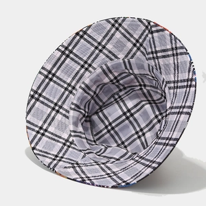 Wide brim sun hat featuring a reversible black and white plaid pattern and a wide structure