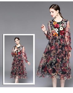 Détail de broderie florale colorée et manches en maille noire sur robe élégante à taille haute