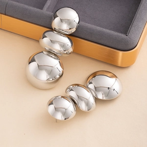Detail view of stacked silver metallic spheres on a minimalist modern abstract earring