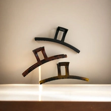 Close-up of three vintage acrylic hair claw clips in tortoiseshell and black colors