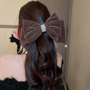 Nœud en velours marron avec strass et pendentif perle, porté sur l'arrière de la tête