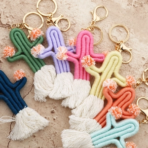 Detailed flat lay of handmade woven cactus keychains in seven vibrant cotton cord colors