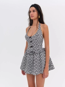 Detail of summer halter plaid mini dress with black bow tie and floral pattern