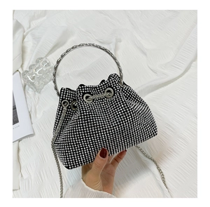 Detail of black mini bucket bag with silver rhinestones and metal chain handle