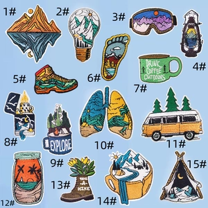 Flat lay of 15 colorful embroidered patches with mountain, camping, and outdoor themes