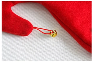 Detail of a red felt Christmas hat showing a gold metal bell and fabric texture