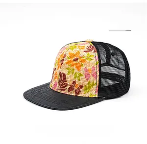 Detail of tropical floral print on straw fabric with breathable black mesh and croc-brim
