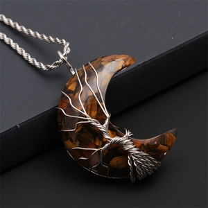Macro view of handmade silver wire-wrapped tree of life on tiger eye moon pendant