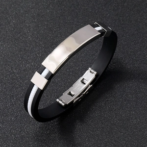 Détail d'un bracelet en silicone noir réglable avec une plaque en acier inoxydable poli