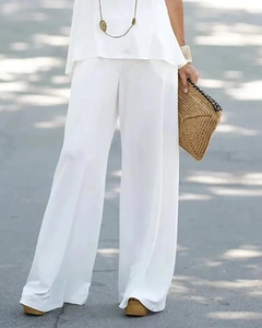 Détail d'un haut sans manches blanc et d'un pantalon large à taille haute
