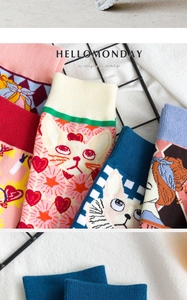 Close-up of vibrant cartoon cat illustrations and pop art patterns on knit crew socks