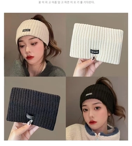 Close-up of ribbed knit sports headbands in cream and black with brand woven label