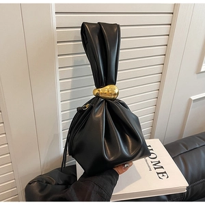 Close-up of black pleated cloud handbag with elegant gold teardrop hardware detail
