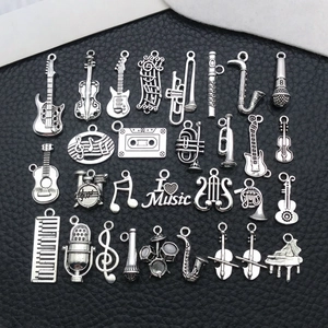 Set of vintage antique silver music instrument and symbol pendants on black leather