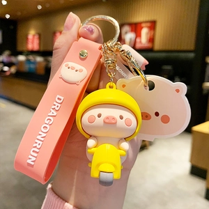 Cute cartoon pig on electric scooter keychain with pink silicone wrist strap and yellow motor