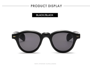 Detail of vintage round sunglasses showing metal hinge and gold arrow accents