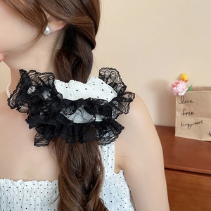 Détail d'un grand chouchou en dentelle noir et blanc avec pois et broderie florale