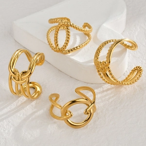 Set of four geometric gold stainless steel open rings with twisted textures on white backdrop