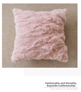 Close-up of pink long plush pillow cover with wavy faux fur texture on woven rug