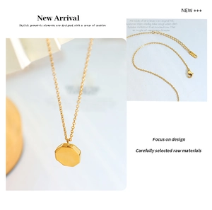 Detail of 18K gold plated octagonal pendant featuring polished finish and clasp stamp