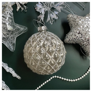 Macro detail of vintage silver glass Christmas ball with diamond texture and glitter