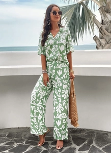 Detail of green and white leaf print fabric on short sleeve shirt and wide leg trousers