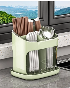 Close-up of green plastic kitchen utensil holder with dividers for forks and spoons