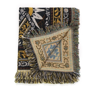 Detail of bohemian woven outdoor camping blanket with colorful fringe and ethnic patterns