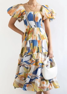 Detail of off-shoulder puff sleeve dress with floral print and white woven handbag