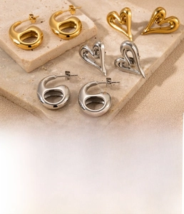 Détail de boucles d'oreilles cœur en acier titane avec placage sous vide doré