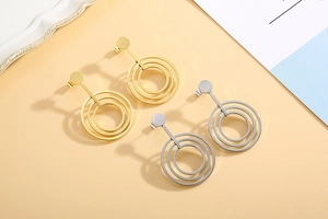 Detail of rose gold and silver triple concentric geometric circle hoop earrings