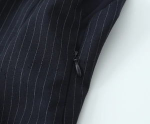 Macro detail of black pinstripe woven fabric featuring a high-quality invisible zipper