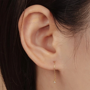 Close-up of a minimalist S925 silver golden ear chain featuring a small turquoise diamond drop
