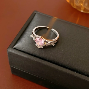 Macro detail of crown ring featuring pink round-cut gemstone and cubic zirconia accents