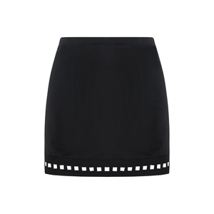 Detail of a black mini skirt with white geometric square cutouts on the hemline