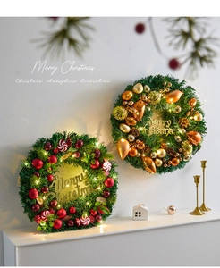 Detail of Christmas wreath with LED lights, pine cones, and Merry Christmas sign