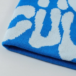 Macro shot of blue jacquard knit fabric showing detailed fiber texture and stitching