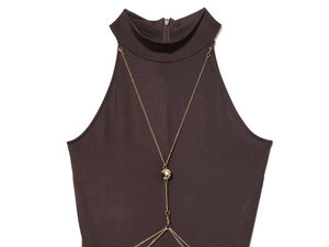 Detail of dark brown halter dress featuring a textured fabric and gold metal chain neckline