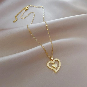 Luxurious gold double heart necklace with sparkling zircon pavé on a soft silk background