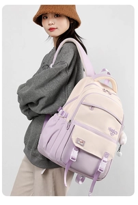 Side view of lavender and cream school backpack with plush ball and hello embroidery