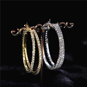 Detailed view of oversized gold and silver hoops set with sparkling rhinestones