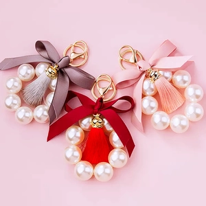 Detailed close-up of colorful ribbon bows with pearl tassels and metal keychains