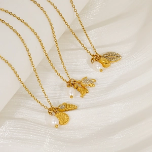 Close-up of gold titanium necklaces with pearl, turtle and seashell ocean pendants