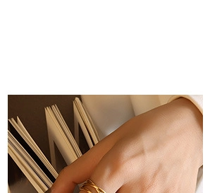 Close-up of minimalist layered gold-plated criss-cross ring worn on a finger